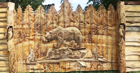 Wood carver makes animal sculptures on wood fence